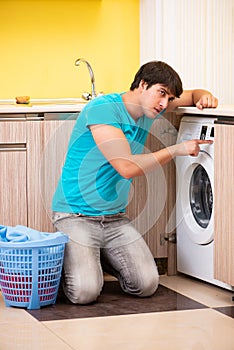 The young husband man doing laundry at home