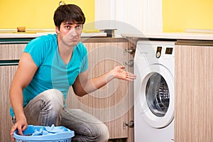 The young husband man doing laundry at home