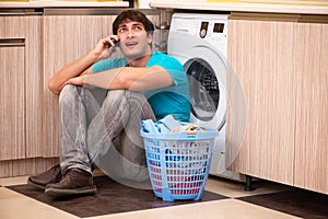 The young husband man doing laundry at home