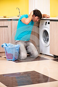 The young husband man doing laundry at home