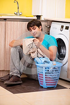 The young husband man doing laundry at home