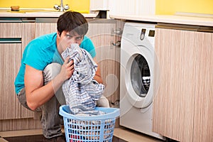 The young husband man doing laundry at home