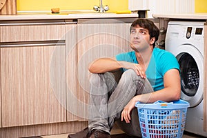 The young husband man doing laundry at home