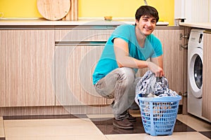 The young husband man doing laundry at home