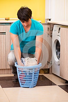 The young husband man doing laundry at home