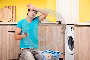 The young husband man doing laundry at home