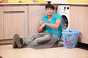 The young husband man doing laundry at home