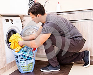 Young husband man doing laundry at home