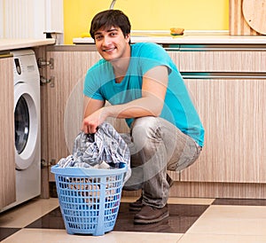 Young husband man doing laundry at home