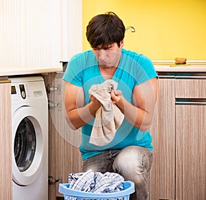 Young husband man doing laundry at home