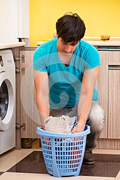 Young husband man doing laundry at home