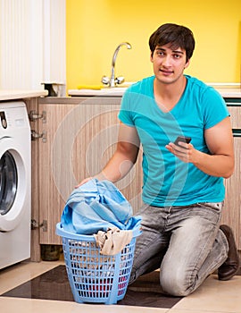 Young husband man doing laundry at home