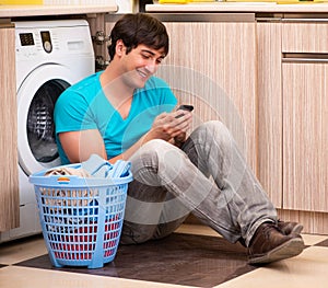 Young husband man doing laundry at home