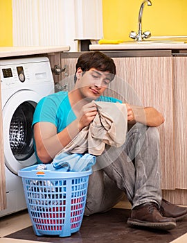 Young husband man doing laundry at home