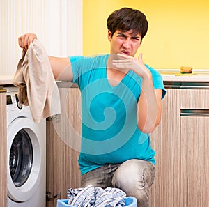 Young husband man doing laundry at home