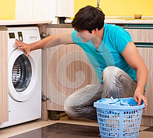 Young husband man doing laundry at home