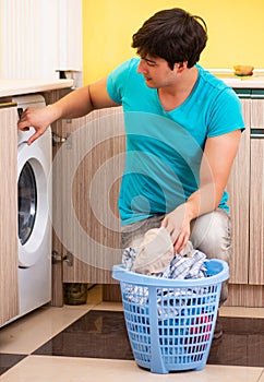 Young husband man doing laundry at home