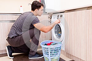 The young husband man doing laundry at home