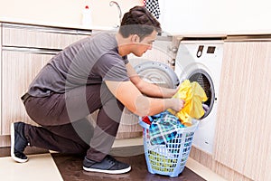 The young husband man doing laundry at home