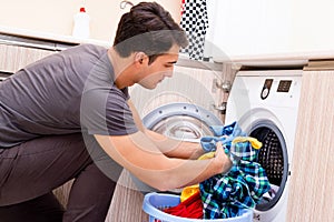 The young husband man doing laundry at home