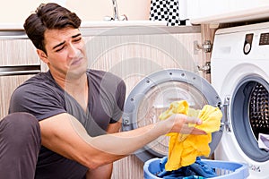 The young husband man doing laundry at home