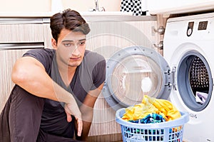 The young husband man doing laundry at home