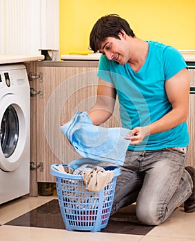Young husband man doing laundry at home
