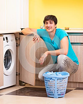 Young husband man doing laundry at home