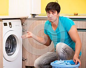 Young husband man doing laundry at home