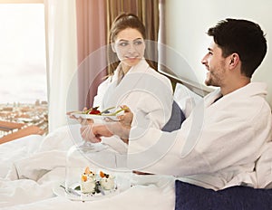Young loving couple having breakfast in hotel room