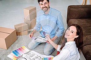 Young husband and wife choosing colors for new home interior