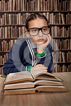 Young hustler with eye glasses or genius in library reading book