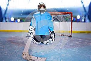 Young ice hockey goalie protecting the net