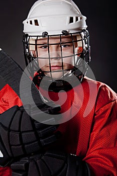 Young ice hockey player on dark background