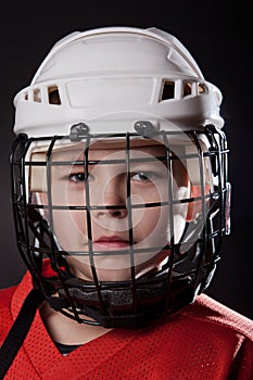 Young ice hockey player on dark background