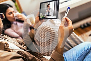Ill couple having medical teleconsultation using digital tablet at home photo