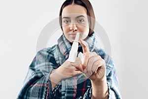 Young ill girl wrapped in blanket uses drops