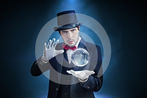 Young illusionist, magician or fortune teller is predicting future with crystal sphere photo