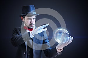 Young illusionist is predicting future and fortune telling from magical ball