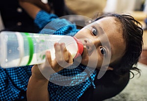 Young Indian boy drinking milk from bottle