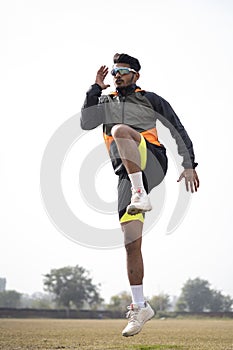 Young Indian boy exercising and jumping on the sports field. Sports and healthy lifestyle concept