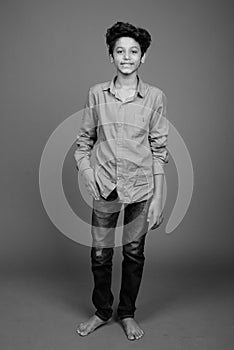 Young Indian boy wearing smart casual clothing against gray background