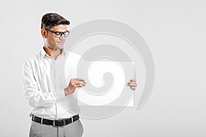 Young Indian business executive showing blank sign board over white background