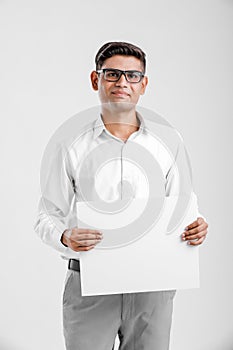 Young Indian business executive showing blank sign board over white background