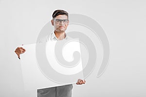 Young Indian business executive showing blank sign board over white background