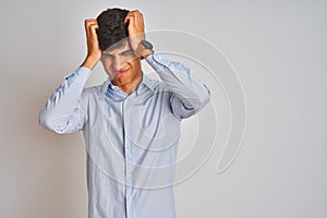 Young indian businessman wearing elegant shirt standing over isolated white background suffering from headache desperate and