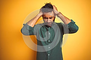 Young indian businessman wearing elegant shirt standing over isolated white background suffering from headache desperate and