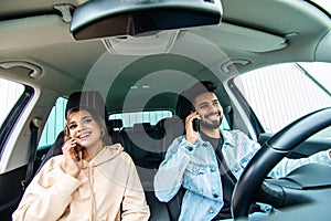 Young indian couple on the red car, man using moblie phones while drive car