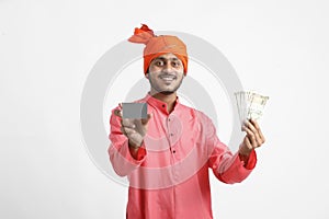 Young Indian farmer posing with currency on white background