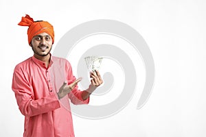 Young Indian farmer posing with currency on white background